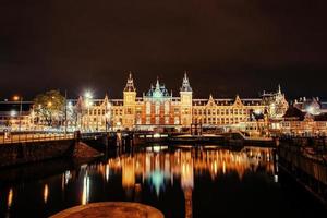 hermosa noche en amsterdam. iluminación de edificios y foto