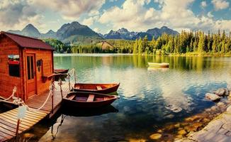Boat on the dock surrounded mountains. Fantastic Shtrbske Pleso photo