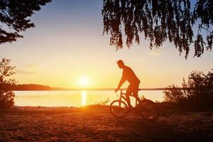 boy on a bicycle at sunset photo