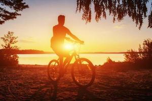 boy on a bicycle at sunset photo