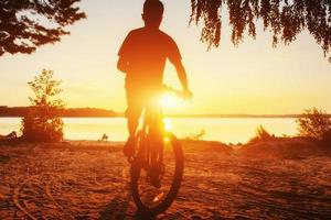 chico en bicicleta al atardecer foto