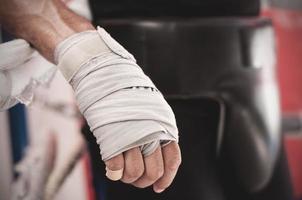 Close up of hand of boxer leaning on ropes on a boxing ring. photo