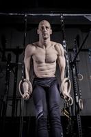 Athlete Doing Push Up With Rings at Gym. photo