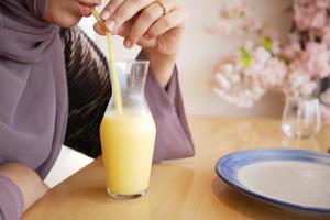 women drinking pineapple juice in a bottle on table photo