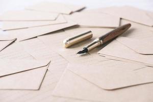 sobre, papel vacío y pluma estilográfica en la mesa foto