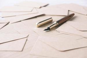 envelope , empty paper and fountain pen on table photo