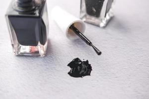 black color nail polish spilling on table photo