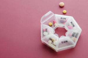 top view of medical pills in a pill box on color background photo