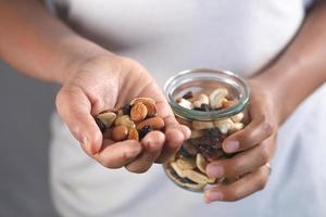 joven comiendo muchas nueces mixtas foto