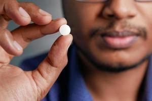 hombre molesto mano sujetando píldoras médicas foto