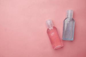 líquido de lavado a mano en un recipiente sobre fondo rosa foto