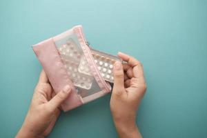 women hand holding birth control pills close up photo