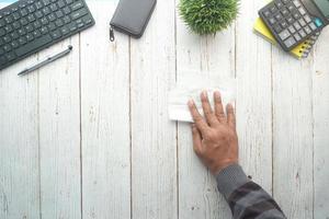 Vista superior de la mesa de limpieza de manos de la persona con un paño foto