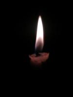 Close up of lighting candles in darkness photo