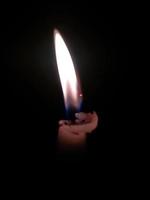Close up of lighting candles in darkness photo