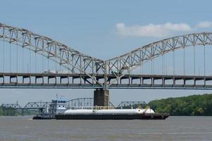 barcaza pasando debajo del puente sherman minton sobre el río ohio en louisville, kentucky foto