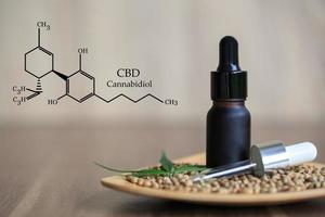 composición de cbd en cannabis, aceite de cannabis en botella de vidrio opaco negro, aceite de cannabis orgánico, concepto de medicina herbaria alternativa. hierbas orgánicas. símbolo científico del cannabis. foto