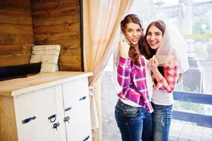Two cheerful girls at checkered shirts on hen party. photo