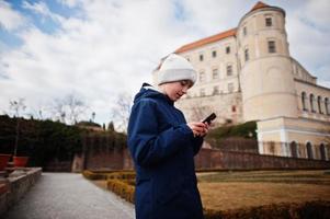 Boy looking at phone in historical Mikulov Castle, Moravia, Czech Republic. Old European town.