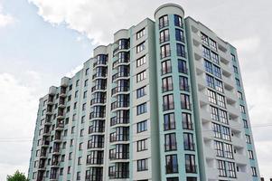 Balcony of new modern turquoise multi storey residential building house in residential area on sunny blue sky. photo