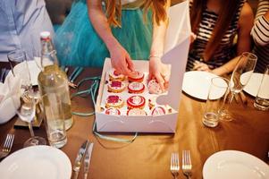 Happy bride receiving cupcakes as a present from her bridesmaids. Bachelorette party. photo