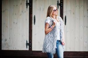 Stylish blonde woman wear at jeans and girl sleeveless with white shirt against street. photo