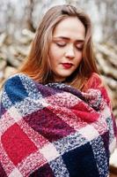 Young hipster girl wear on blanket against wooden stumps on wood. photo