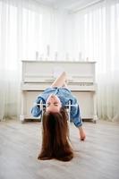 Young tender sexy brunette girl in underwear and denim shirt posed against piano. Studio fashion portrait of model. photo