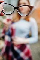 Girl gives her friend glasses, soft focus. Bad eye vision of people. photo