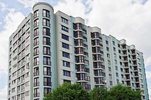 Balcony of new modern turquoise multi storey residential building house in residential area on sunny blue sky. photo