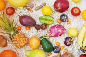 Exotic fruits on wooden background. Healthy eating dieting food. Pitahaya, carambola, papaya, baby pineapple, mango, passion fruit, tamarind and other. photo