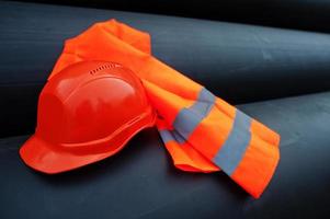 Safety orange worker helmet at steel pipes. photo
