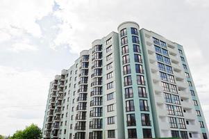 Balcony of new modern turquoise multi storey residential building house in residential area on sunny blue sky.