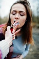 Hand of girl with cigarette lighter. Stop smoking social problem. Friends smoke. photo