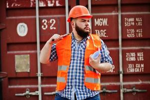 Beard worker man suit construction worker in safety orange helmet with adjustable wrench. photo