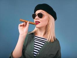 portrait of blonde beautiful woman in hat and sunglasses with cigar in cuban Che Guevara style photo