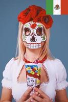 mujer rubia con máscara mexicana en la cara. concepto de viaje y cultura foto