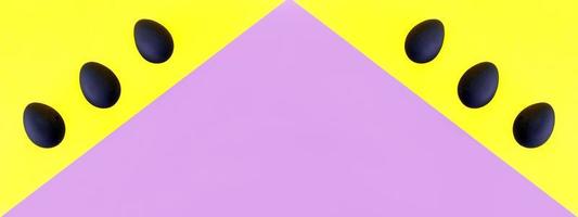 huevos negros sobre el fondo amarillo y violeta. pascua, diversidad, geométrico, patrón, concepto de comida