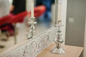 Candle on silver candlestick at beauty salon against mirror. photo