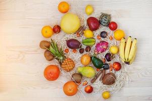 Exotic fruits with small overland turtle on wooden background. Healthy eating dieting food. photo