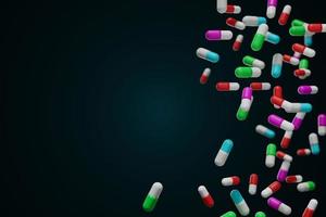 falling capsules medication on dark background photo