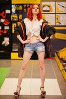 Red haired model posed weared on working jacket at store or household shop of working tools. photo