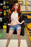Red haired model posed weared on working jacket at store or household shop of working tools. photo