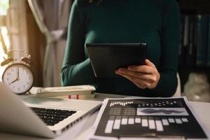 businessman working with digital tablet computer and smart phone with financial business strategy layer effect on desk in morning light photo