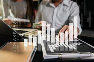 Business documents on office table with smart phone and calculator digital tablet and graph photo