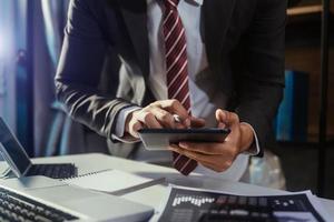 business documents on office table with smart phone and digital tablet and graph financial and man working photo
