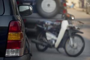 parte trasera del estacionamiento de autos negros al lado de las calles. ambiente en el mercado por la mañana. borrosos hay aparcamientos alineados en frente. foto