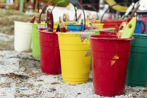 colores vivos de pinturas al óleo en vasos de plástico. vasos de plástico colocados en el suelo del parque. foto