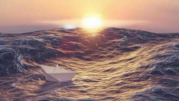 sunset with paper boat fighting wave in ocean, leadership and business concept photo