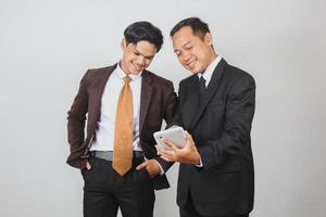 Two Asian businessman in suit discussing using smart phone photo